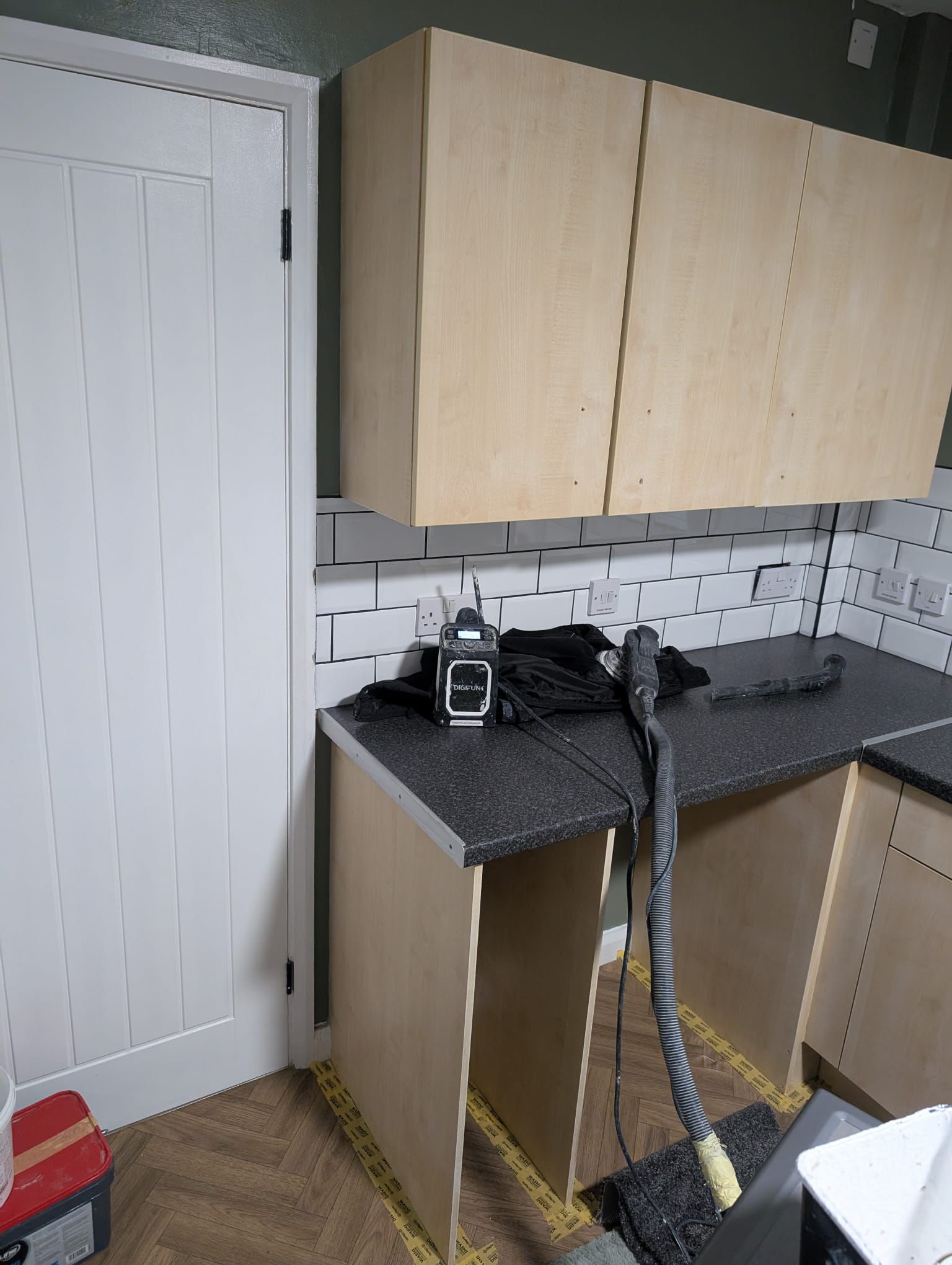 Kitchen with freshly painted dark green walls and tile backsplash